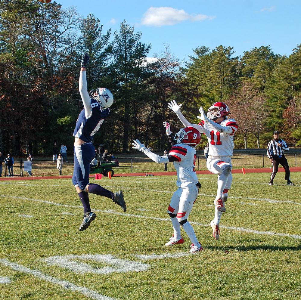 Henry Berry, far right, and Quinn Chisholm (center) jump for the ball. Photos by Mari Huglin