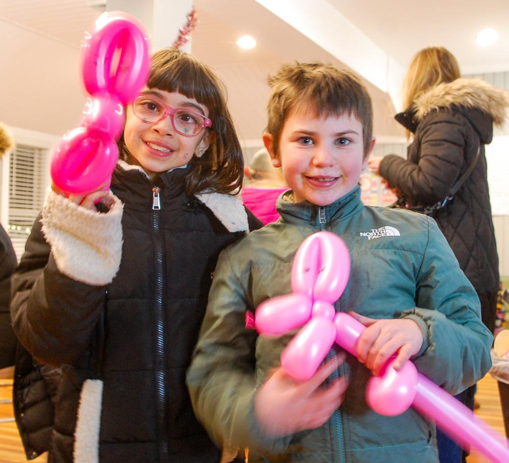 Aria Bell (left) and Margot Ketchel (right) show off their balloon animals at the annual YMCA tree lighting. Photos by Mari Huglin
