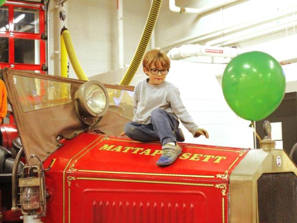 Vincent Bradley, 6, of Mattapoisett climbs on top of a vintage fire vehicle. Photos by Grace Ann Natanawan