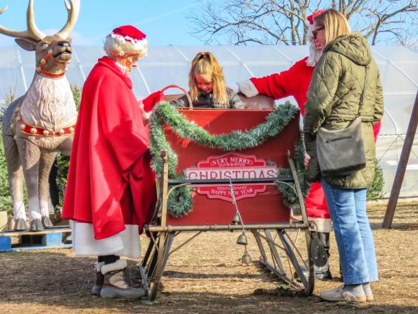 Grace Viglianti, center, and her mother Allie, right share a moment with the Clauses at Cervelli Farm Stand on Sunday, Dec. 7. Photos by Grace Roche