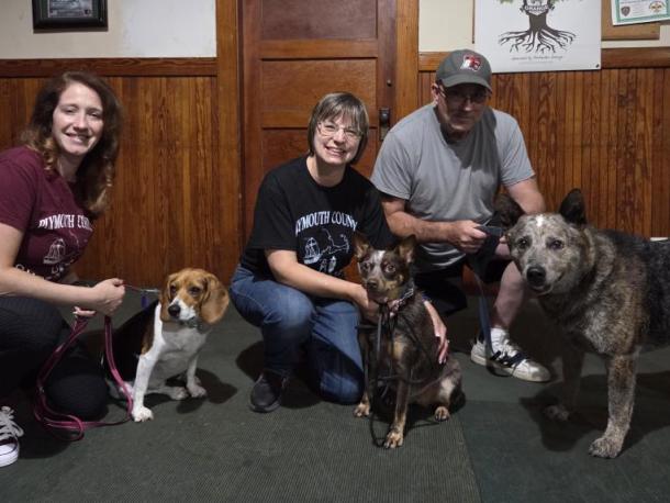 Dog trainers Cristina Fredette and Sherri Swindle, as well as Swindle’s husband, pose with their dogs. 