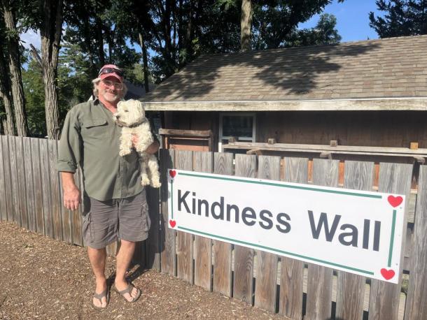 Stan Bradford holds his dog Goodness in front of his Kindness Wall at his property at 468 Wareham Road. Photos by Grace Roche