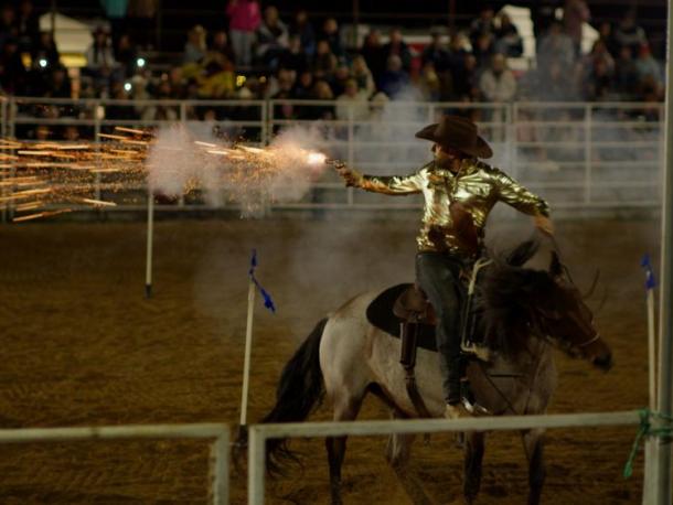 A rider shoots a gun during the Sept. 19 rodeo. Photo by Benjamin Martins
