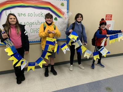 Fifth grade students Fiona Payne, Wyatt Churchill, Jacqueline Cobler and William Lucy hold the banner they helped to create.