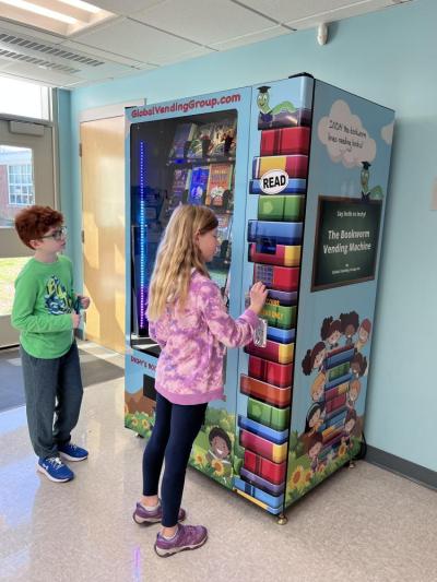 Eli Linane, left, and Cora McNeany use their tokens to buy a book from the vending machine at Rochester Memorial School. Photos courtesy: Rochester Memorial School.