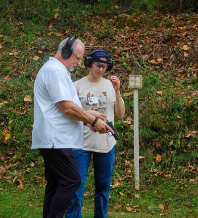 One coach teaches Autumn Tilley about a pistol. One coach teaches Autumn Tilley about a pistol.