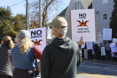 Paul Duffy and Helen L. of Mattapoisett hold "No Kings" signs warning against fascism in the United States.