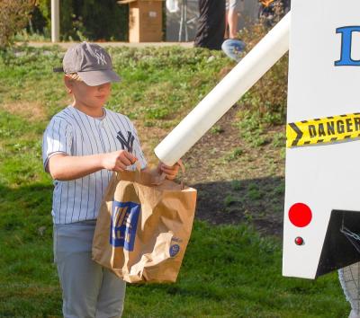 A Yankee baseball player recieves candy from the Public Works candy tube. A Yankee baseball player recieves candy from the Public Works candy tube.