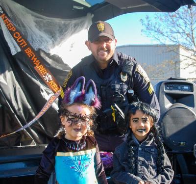 Sergeant Sean Day with Lexie Dupont age 5, dressed as a magical vampire bat, and Hazel Moore age 5, dressed as Wednesday Addams. Photos by Mari Huglin  Sergeant Sean Day with Lexie Dupont, dressed as a magical vampire bat, and Hazel Moore, dressed as Wednesday Addams. Photos by Mari Huglin