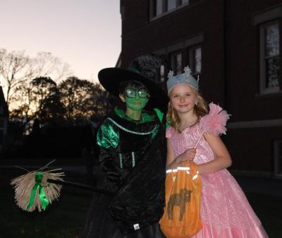 The Wicked Witch of the West and Glinda smile for a photo.
