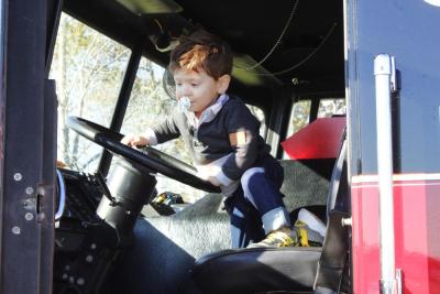 Declan Ferreira, 2, of Somerset climbs into a Mattapoisett fire truck.