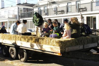 Fall fest attendees hop onto a hay ride.