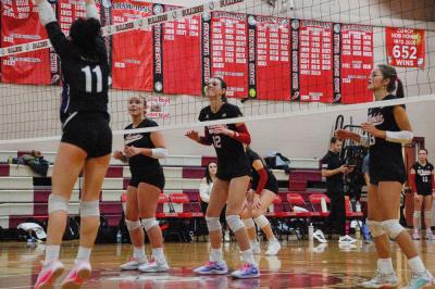 Molly Morrison, Piper Newell, and Molly Franco step up to the net to get ready for a block.