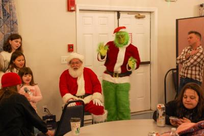 Santa, the Grinch and carolers join together to sing. 