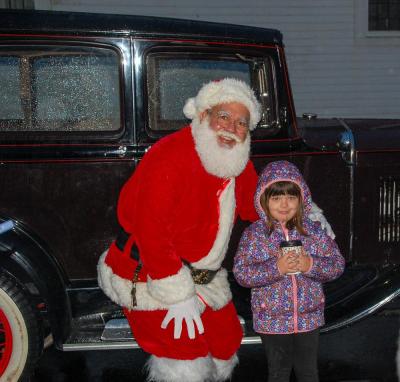 Santa poses with Isla Durant infront of his temporary sleigh-car.