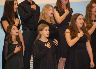 The Showstoppers singing troupe sing the national anthem. 