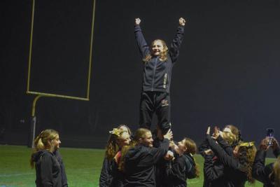 The cheerleaders pose in a stunt.