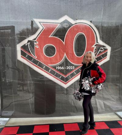 Elaine Botelho poses infront of a 60th anniversary poster. Source: Elaine Botelho