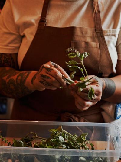 Ortiz cleans herbs and vegetables from her garden. Photo source: Andrew Thomas Lee