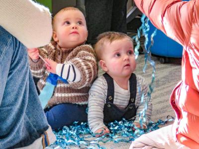 Landon, 11 months,  and Marcus, 8 months, are mesmerized by shiny streamers at the Elizabeth Taber Library on Wednesday, Dec. 31. Photos by Grace Roche 
