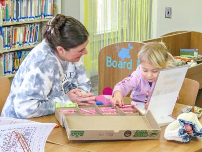 Jackie Steger, left, and Faye, 2, color together.