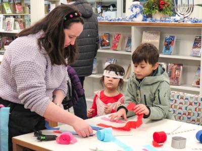 Macy Davis guides young visitors through making a streamer wand. 