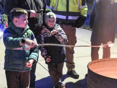 A young attendee roasts a marshmallow over a flame.  