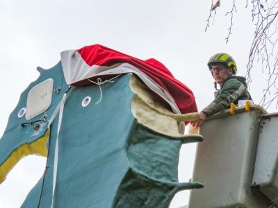G. Bourne Knowles used his landscaping equipment to reach the top of the statue and install the new hat Dec. 6.  Photos by Grace Roche