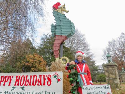 Mary Dermody poses in front of Salty the seahorse wearing the new hat she helped make. 