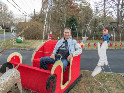 Marino Carrier sits in a sleigh on his front lawn, one of the many decorations at the Mattapoisett resident's house. Photo by Grace Roche