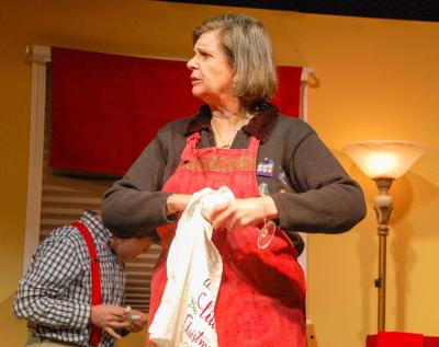 Michele Letourneau, as Emily, cleans a glass while chatting with her family. 
