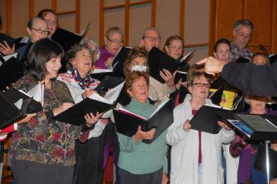 The choir warms up their vocals before heading into a song.