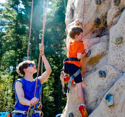 Kieran Adams climbs up a rock wall while being belayed by a Carabiner's Climbing Gym employee at the Old Colony Fall Family Festival on Saturday, Oct. 4. Photo by Mari Huglin 