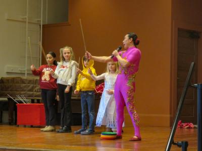 Liu teaches young volunteers how to keep plates spinning on a stick. 