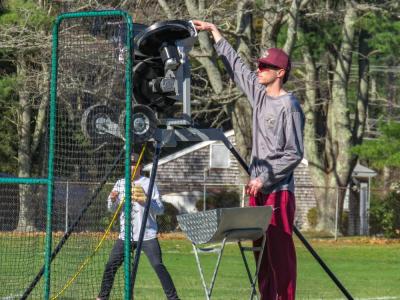 Coach Liam Stuart feeds balls to the batters. 