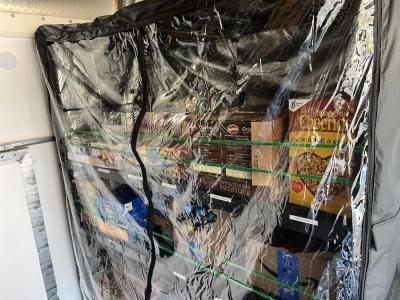 Inside the truck, boxes of food ready for distribution line shelves. 