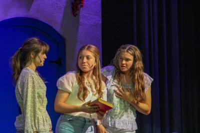 Sophie tells her friends Lisa, left, played by Kennedy McKay, and Ali, right, played by Tenley Lane, that she secretly invited her possible fathers to the wedding.  