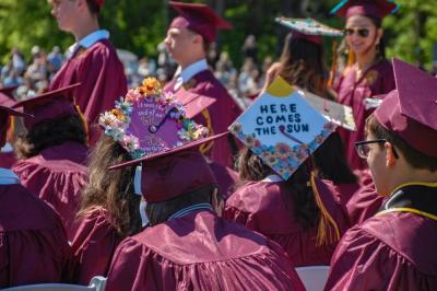 Lyrics adorn some of the graduates' caps. 