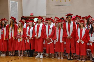 The crowd cheered as the graduating class stood together. 