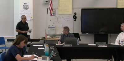 Luis Rivera, left, speaks during a May 7 school committee meeting. Photo source: ORCTV