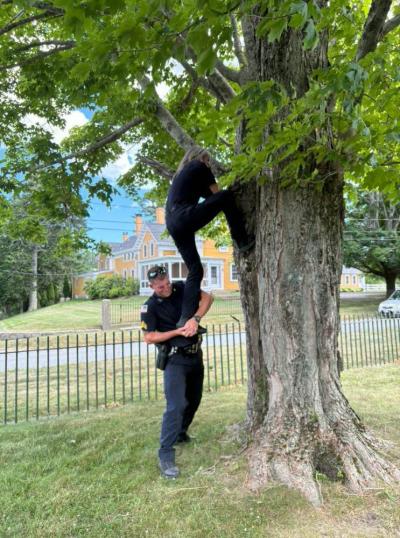 Sgt. Connor Leddin holds up Connolly as she reaches for the young animal. 