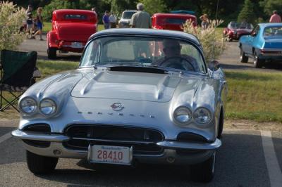 A man sits in his blue Corvette. 