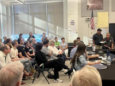 People crowded the meeting, split between attendees who supported and questioned the school's response. 
