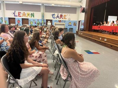 NoneSixth grade students listen as their classmate speaks during the graduation. 