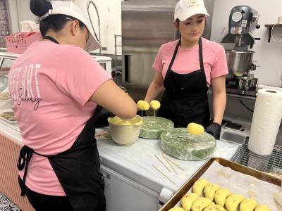 Two of the bakers set dipped pastries aside to harden. 
