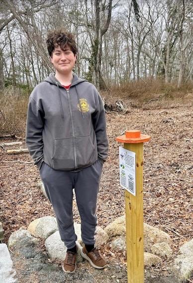Iain McManus smiles next to one of the photo post he built. 