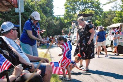 Evelyn Hussey, 6, and Valerie Hussey, 6, grab candy thrown along the parade route. 