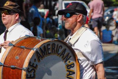 A member of the Portuguese-American Band marches down the street with his drum.