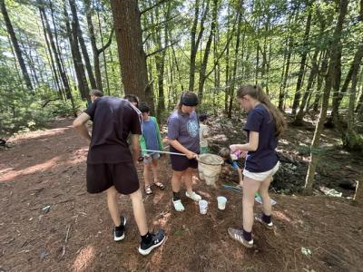 Program participants use nets and other tools to catch woodland animals. 