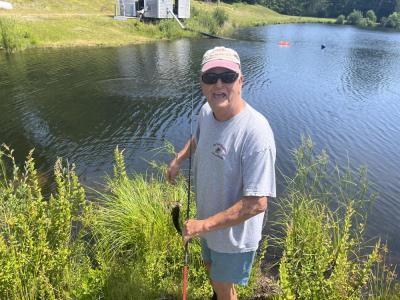 Woody Hartley holds up a bass he caught in the pond. 
